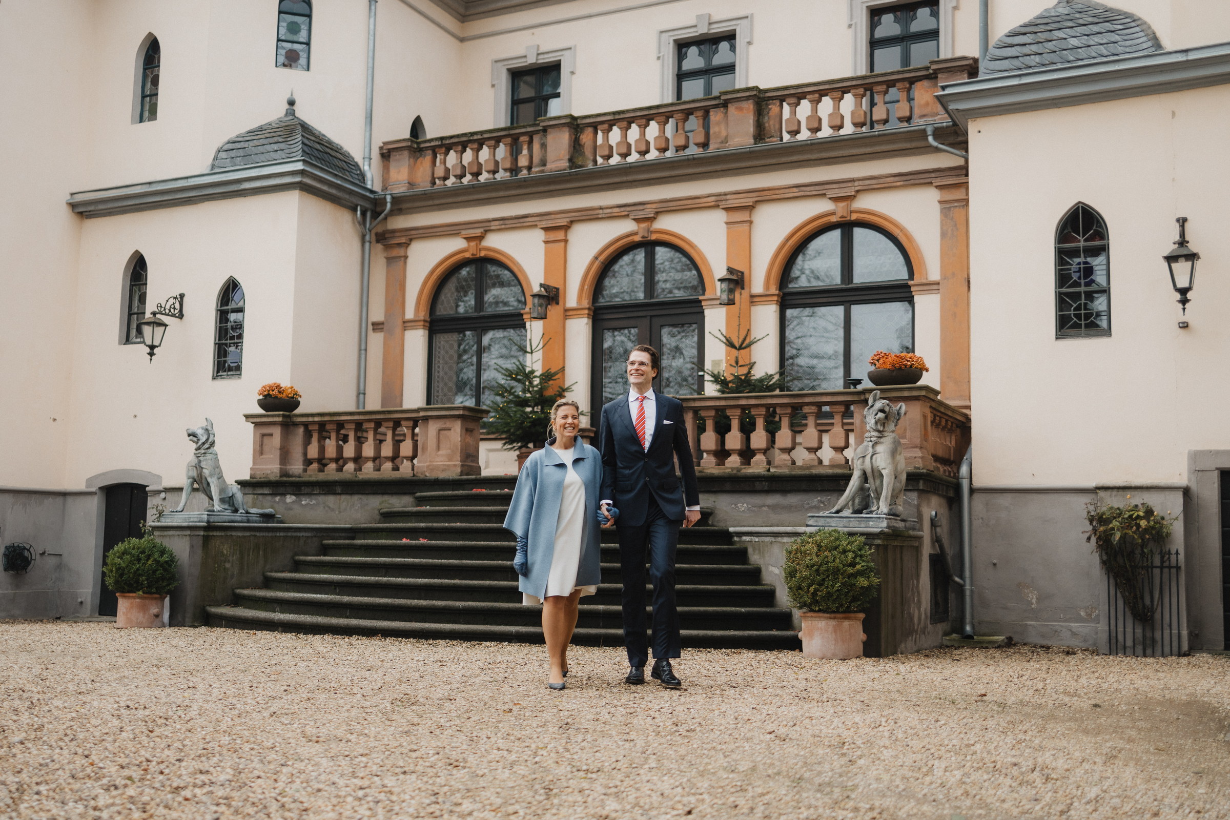 Brautpaar kommt die Freitreppe der Burg Kriegshoven herunter, Löwenfiguren am Geländer