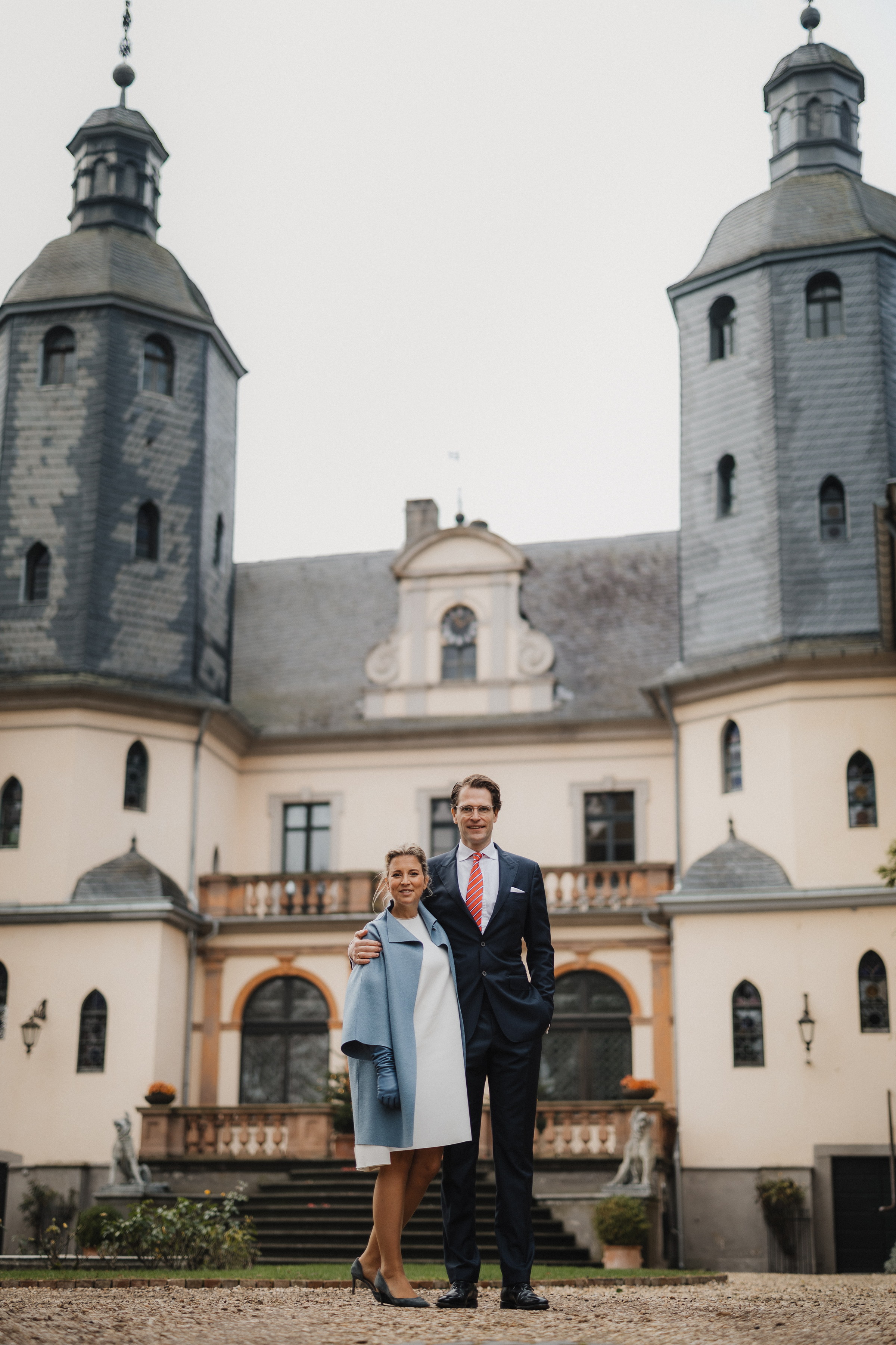 Brautpaar steht zwischen den beiden Ecktürmen im Innenhof der Burg Kriegshoven