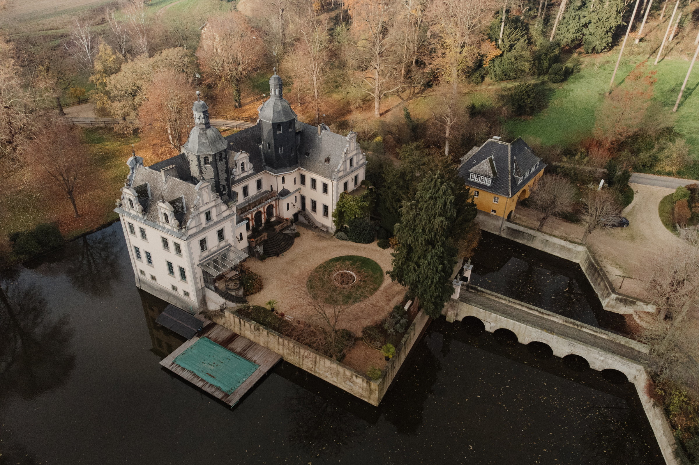 Luftaufnahme der Burg Kriegshoven mit Wassergraben und Park im Winter