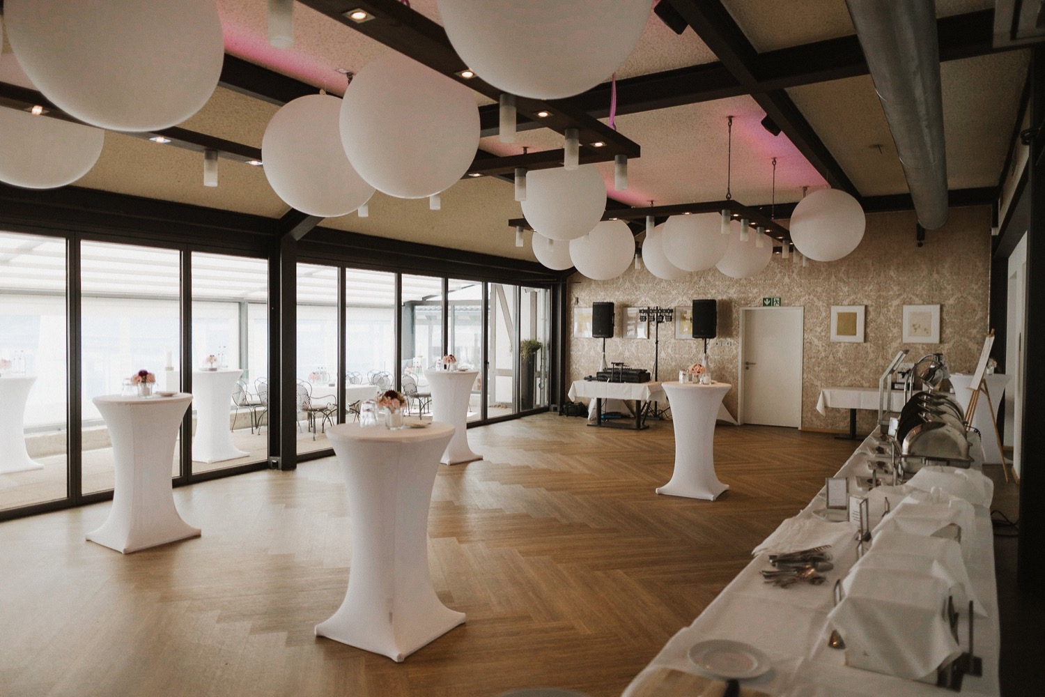 Festsaal des Club Astoria mit Stehtischen, großen Kugelleuchten und Buffet