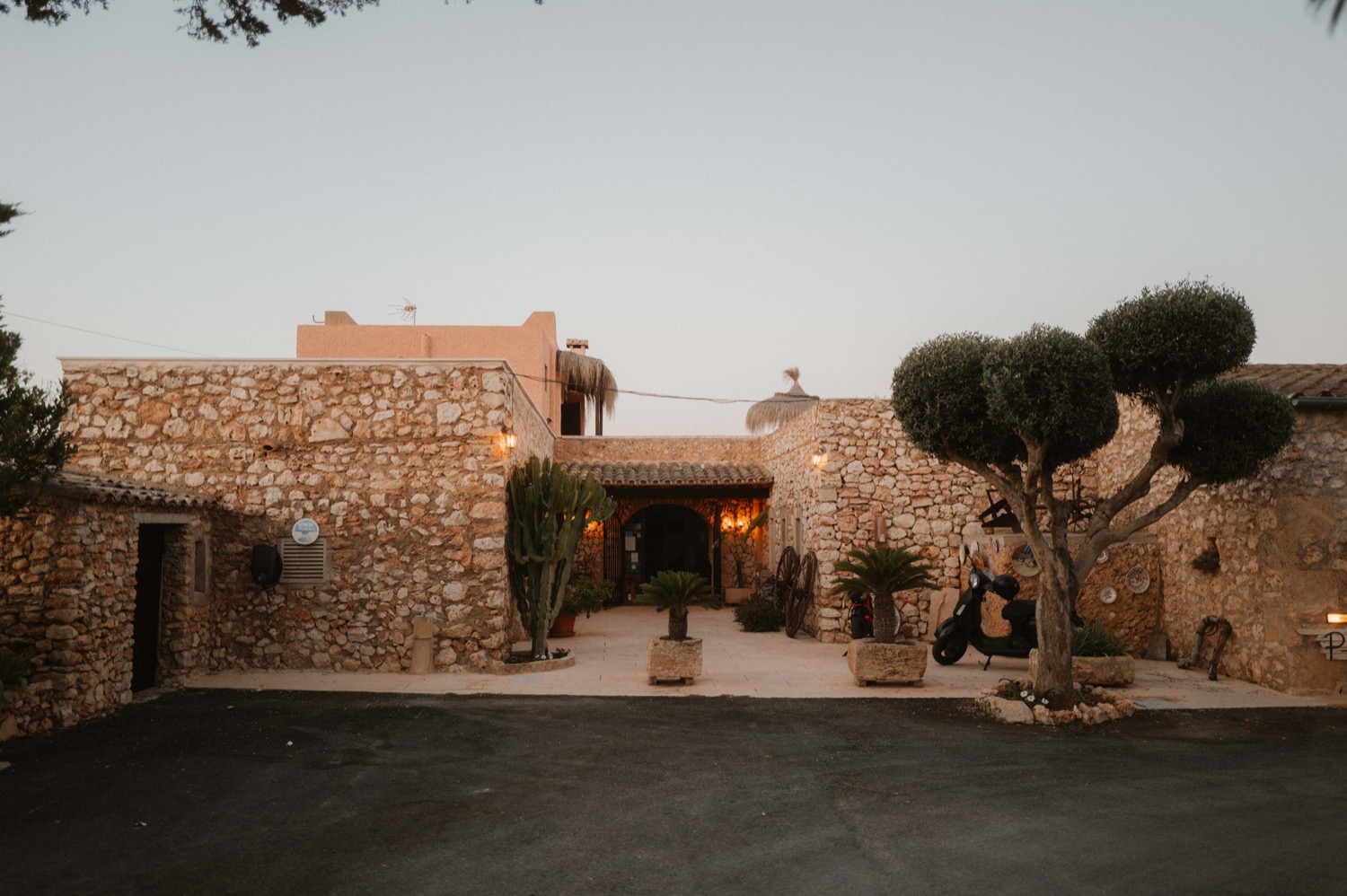Innenhof der Finca Sa Tanca mit Natursteinmauern und Olivenbäumen in der Abenddämmerung