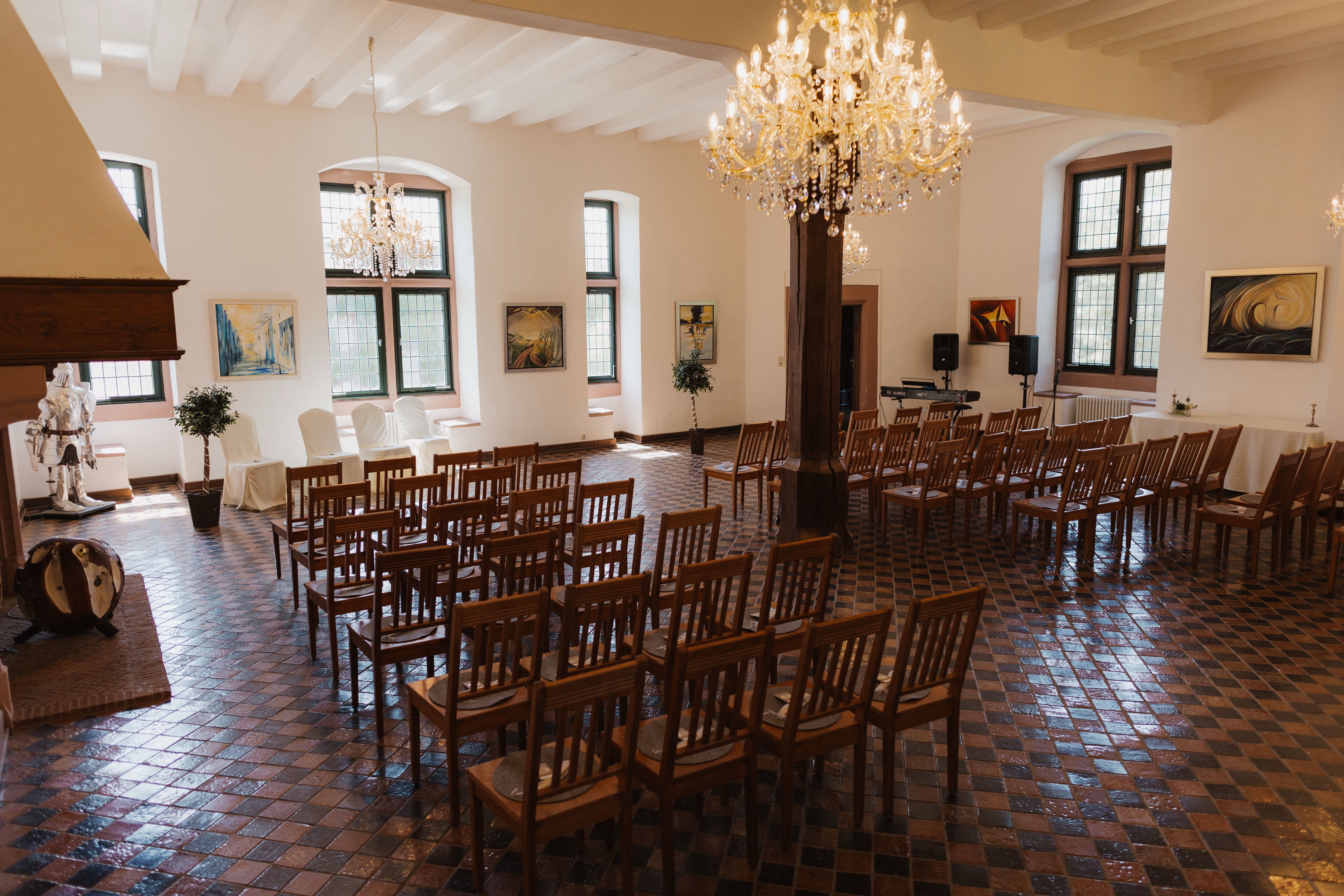 Bestuhlter Rittersaal mit Kronleuchtern und Kamin auf Burg Konradsheim