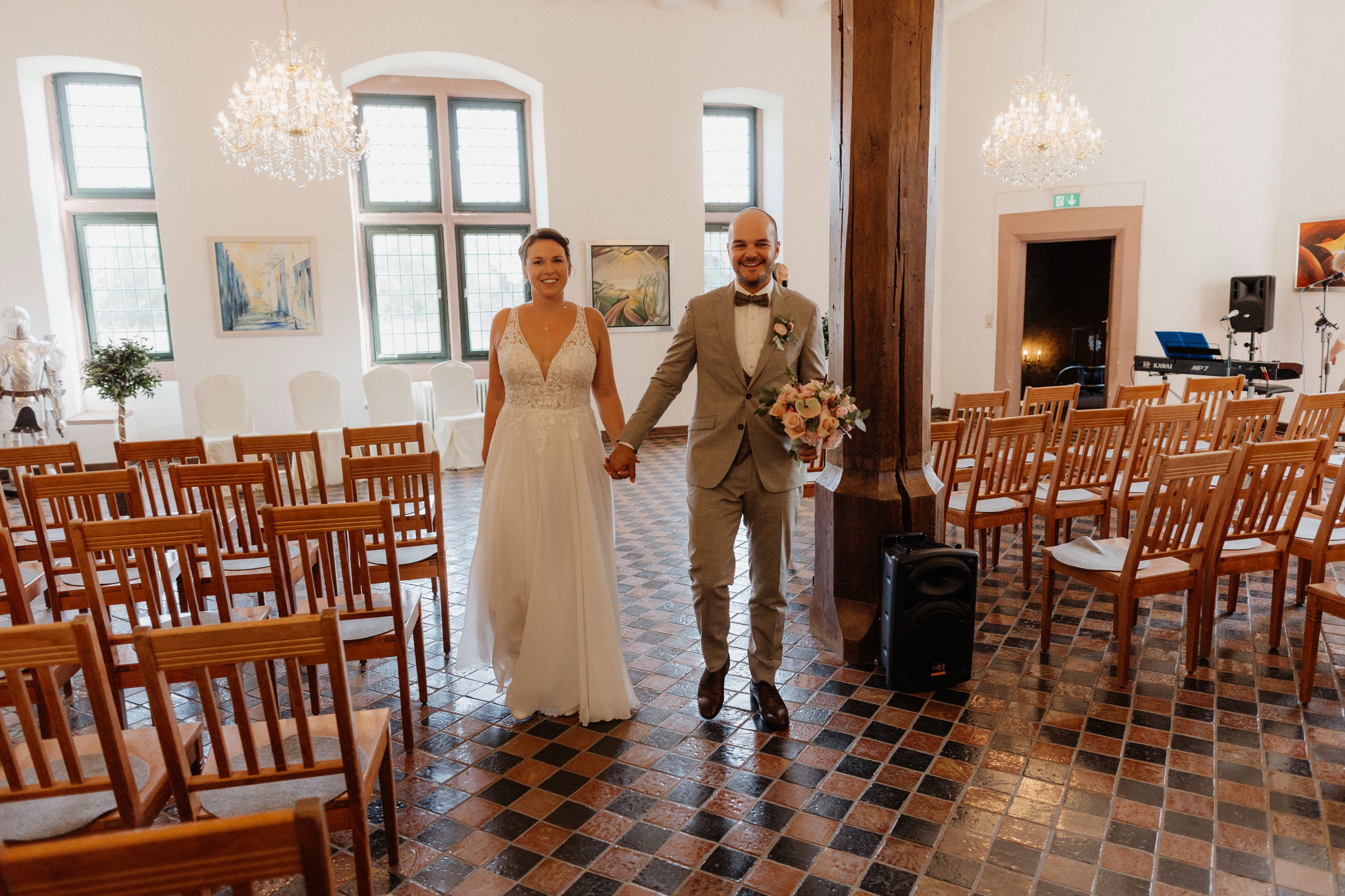 Brautpaar geht Hand in Hand durch den Rittersaal hinaus