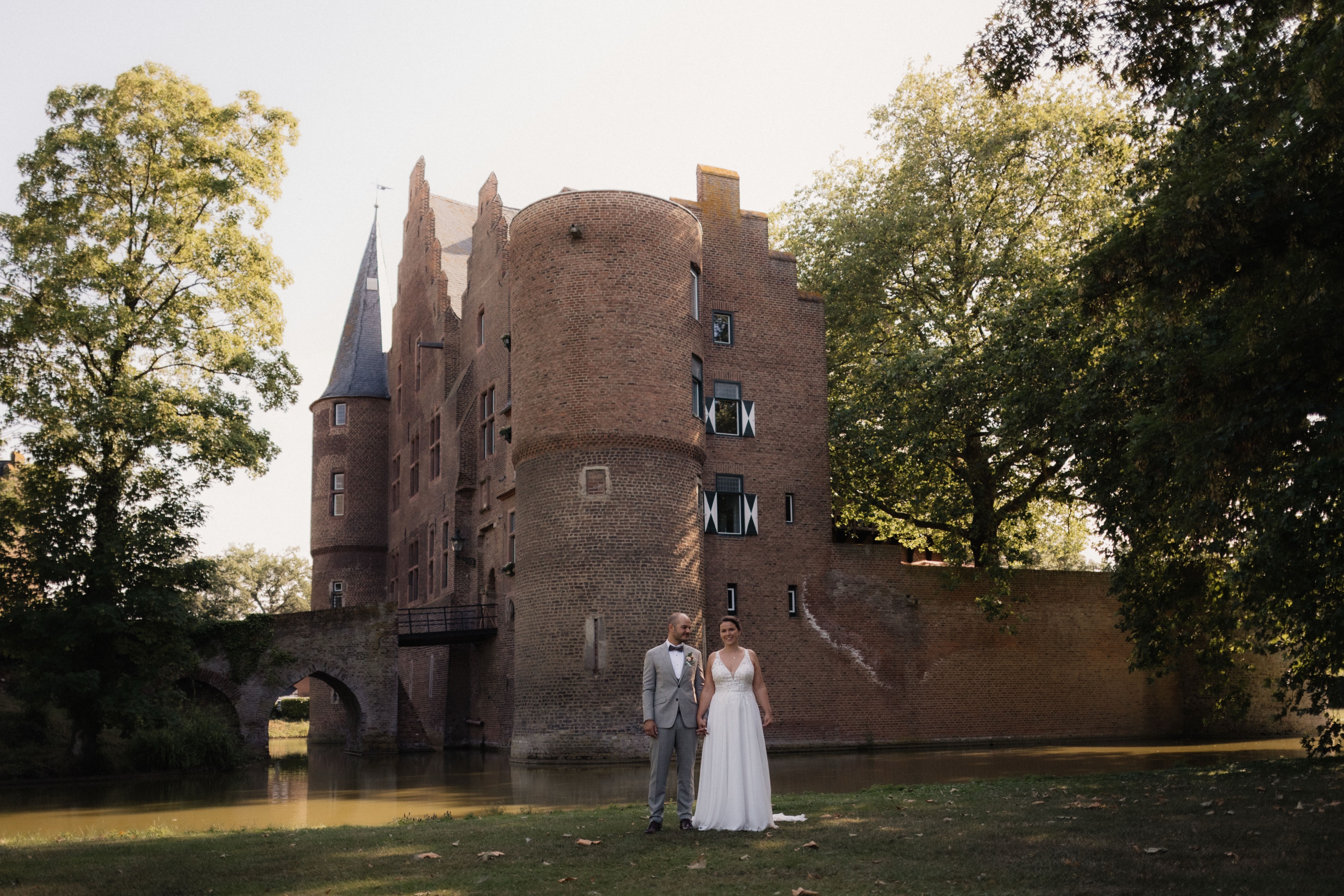 Burg Konradsheim mit Wassergraben, das Brautpaar klein davor