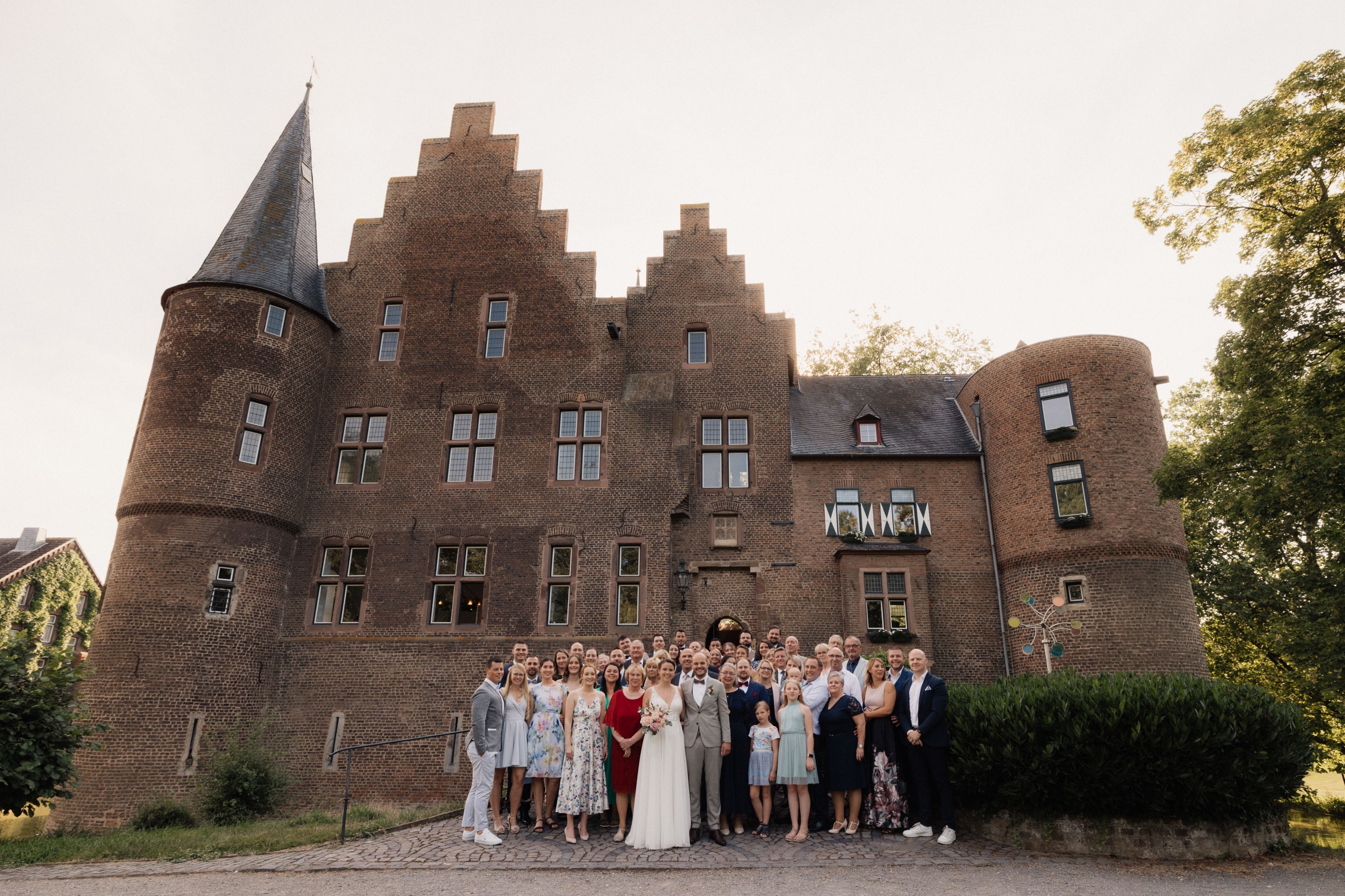 Gruppenfoto der Hochzeitsgesellschaft vor der Burg Konradsheim