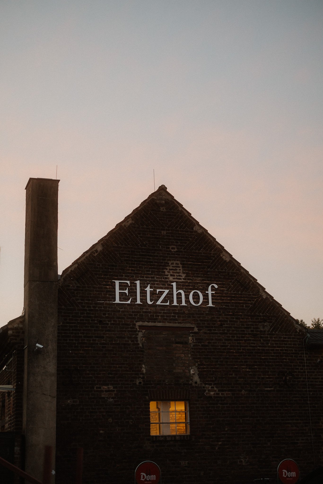 Backsteingiebel des Eltzhofs mit dem Schriftzug Eltzhof in der Abenddämmerung