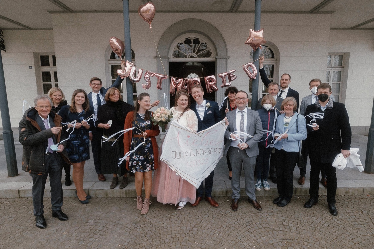 Gruppenbild der Gäste vor dem Eingang, darüber die Ballongirlande
