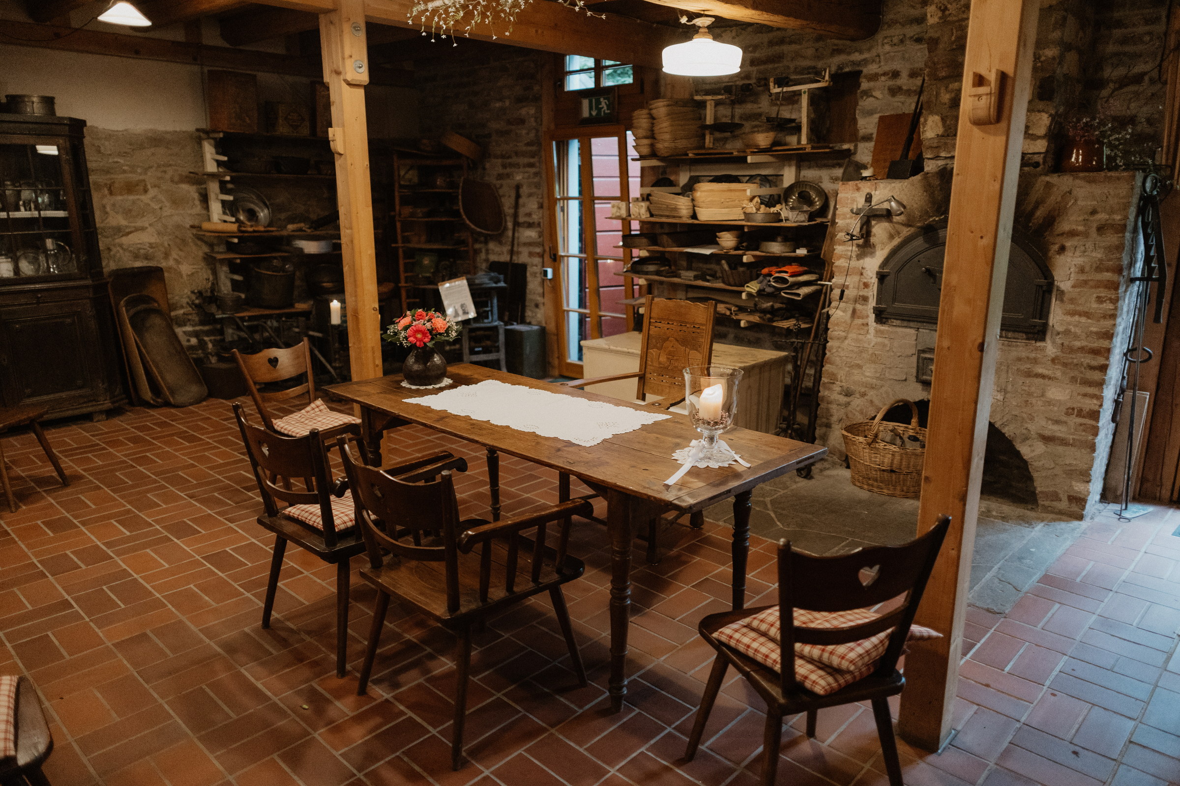 Rustikale Backstube der Lambertsmühle mit gedecktem Holztisch und altem Steinofen