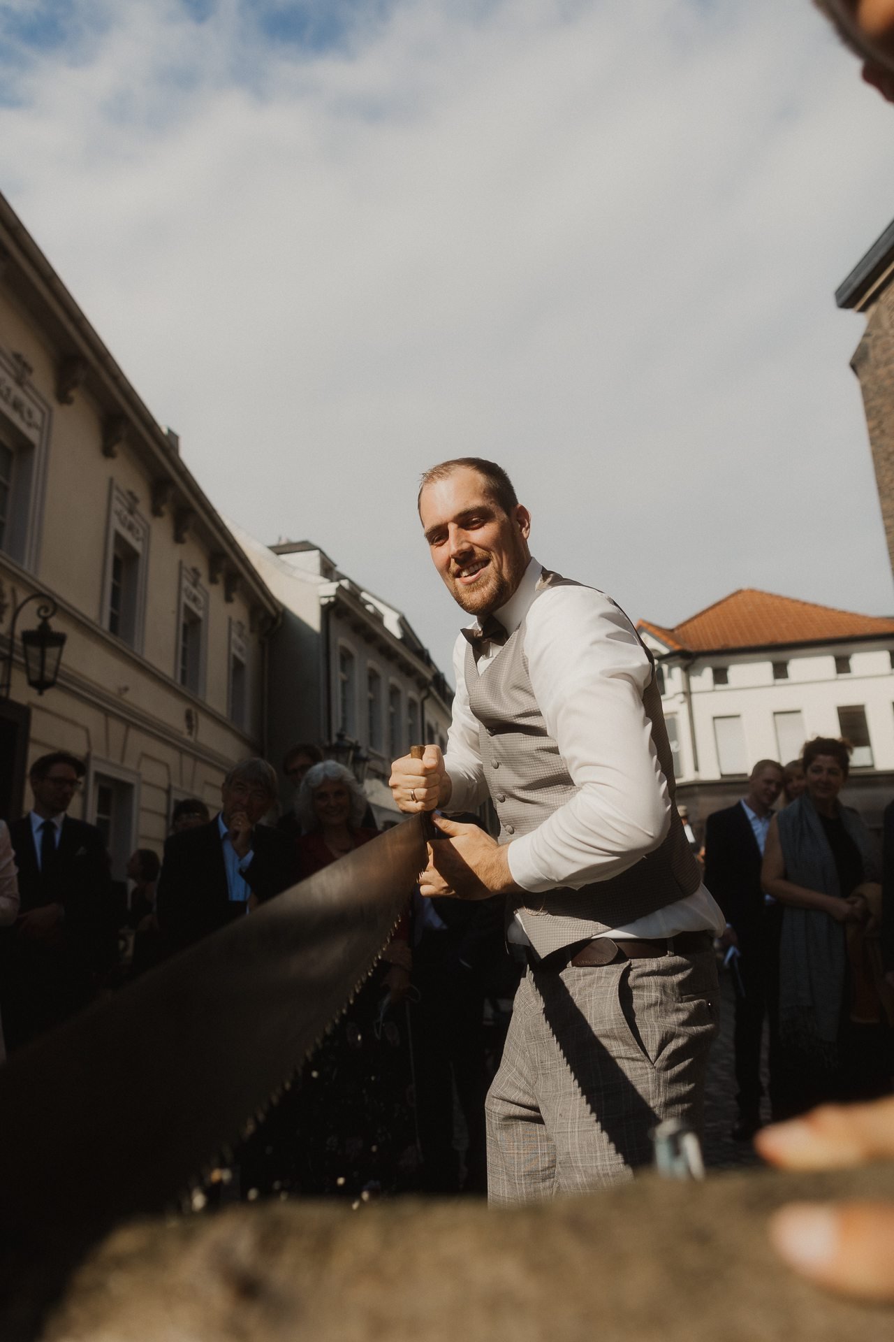 Gast beim Baumstammsägen vor der Kirche
