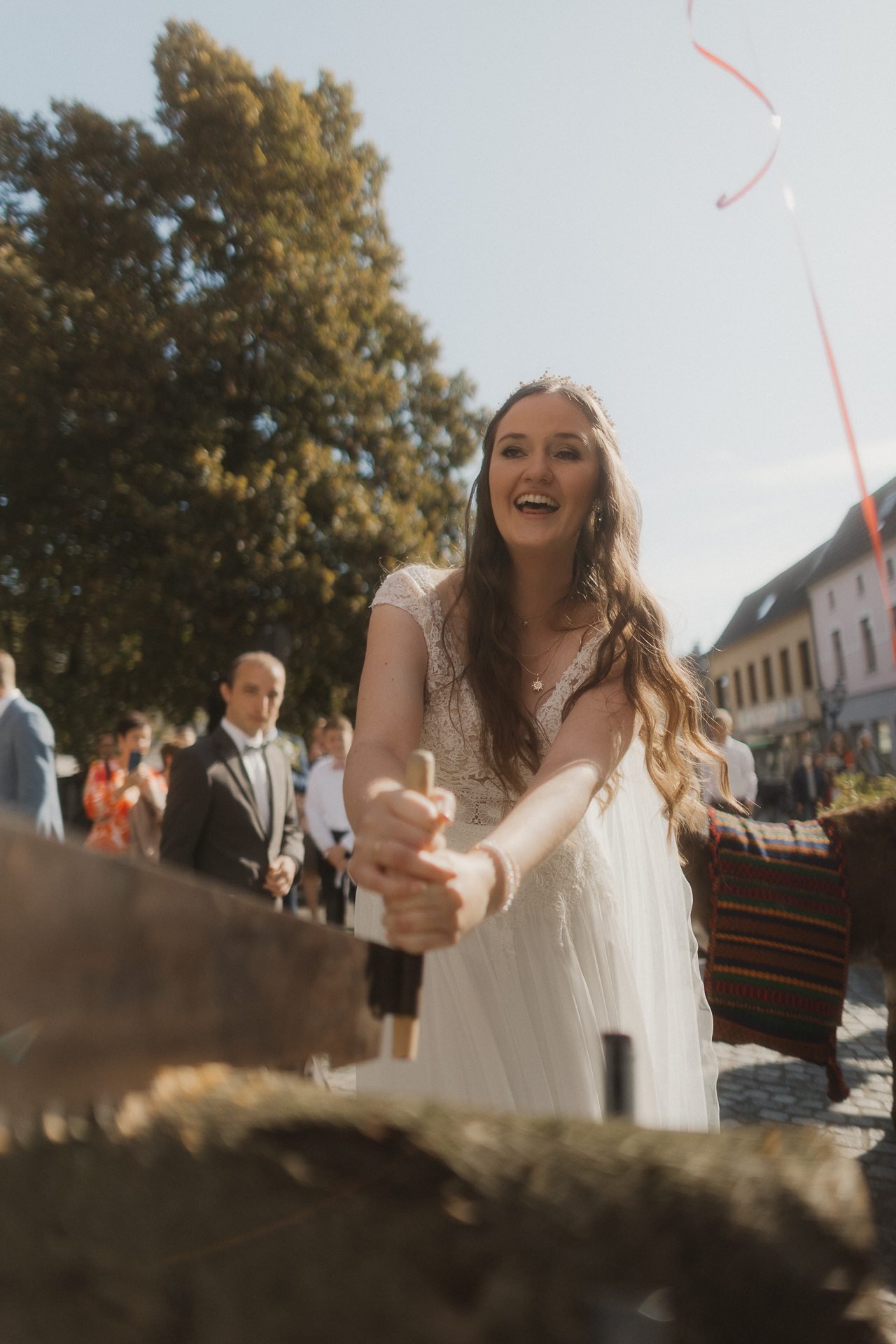 Braut lacht mit einem roten Herzballon in der Hand
