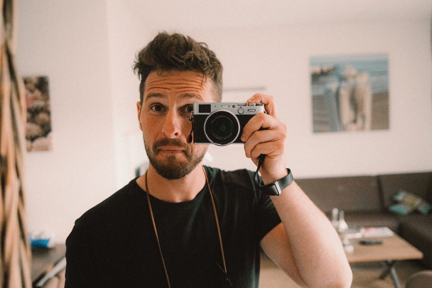 Fabian Rudolf hält seine Kamera vor das Gesicht und fotografiert sich im Spiegel