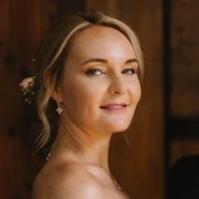 Frau mit Blüte im Haar blickt über die Schulter in die Kamera